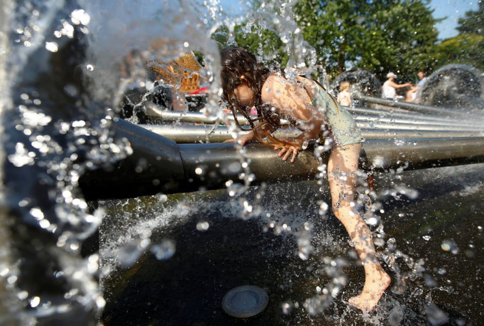 A girl plays in a fountain on a hot summer day in Cologne, Germany, June 26, 2019. REUTERS/Thilo Schmuelgen