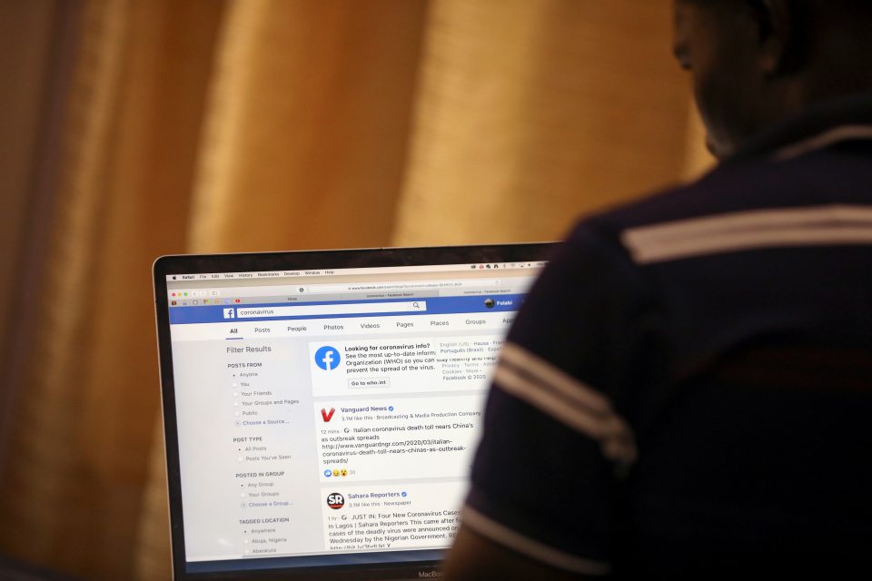File Photo: Man Opens The Facebook Page On His Computer To Fact Check Coronavirus Disease (covid 19) Information, In Abuja