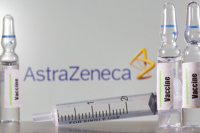 A Test Tube Labelled With The Vaccine Is Seen In Front Of Astrazeneca Logo In This Illustration Taken