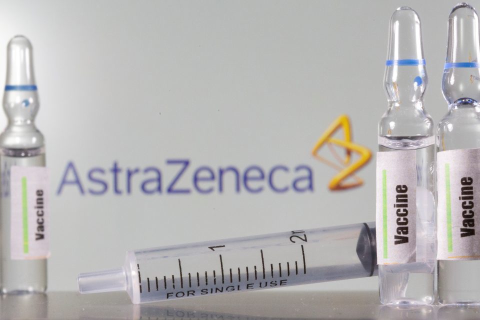 A Test Tube Labelled With The Vaccine Is Seen In Front Of Astrazeneca Logo In This Illustration Taken