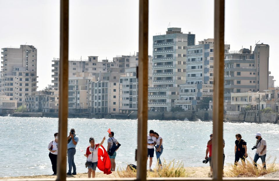 People Walk On A Beach Inside An Area Fenced Off By The Turkish Military Since 1974 In The Abandoned Coastal Area Of Varosha