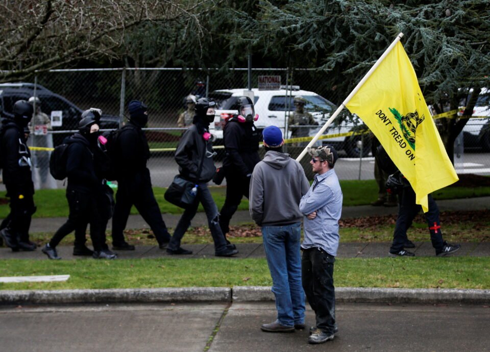 Members Of Antifa Trade Insults With Two Men, One Carrying A Gadsden Flag, As Members Of The National Guard Stand Outside Of The Washington State Capitol Building Ahead Of Anticipated Rallies In Olympia, Washington