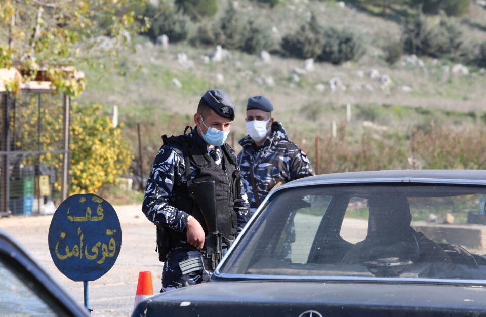 A Police Officer Wearing A Face Mask Talks With A Driver At A Checkpoint, As Lebanon Announced A Full Lockdown For Three Weeks To Stem A Rise In Coronavirus Disease (covid 19) Infections, In Marjayoun