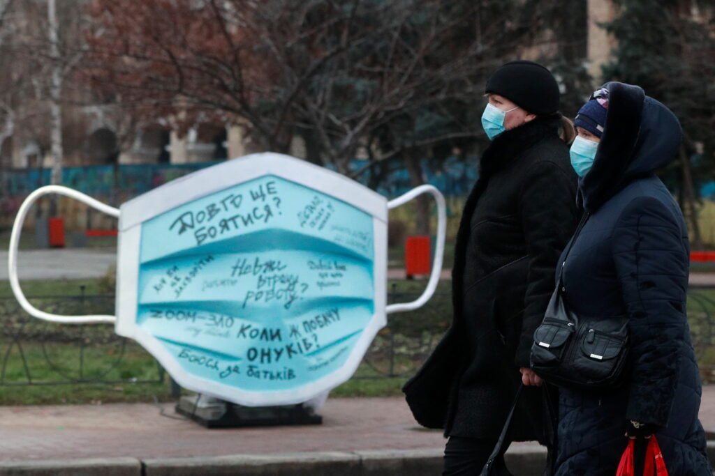 Women Walk Past An Installation Showing A Protective Face Mask Amid The Coronavirus Disease Outbreak In Kyiv