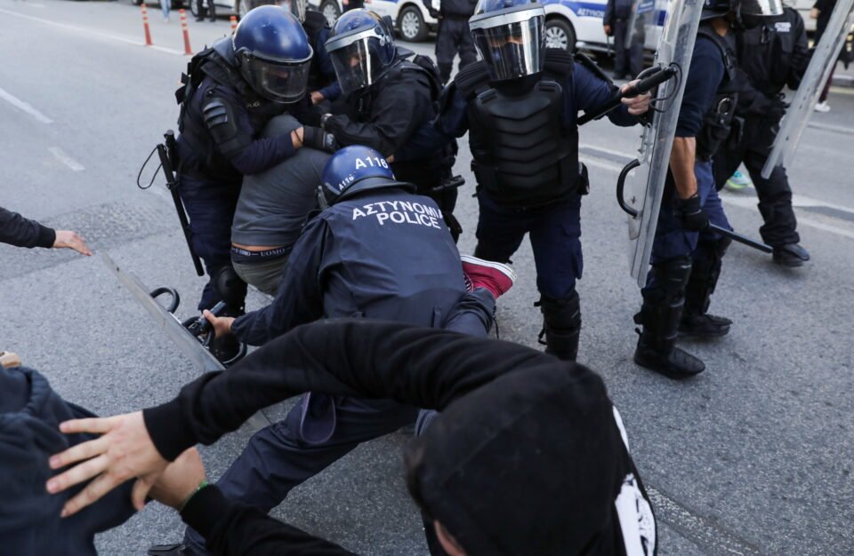 police officers detain a protester during a rally against corruption and covid 19 restriction measures, in nicosia
