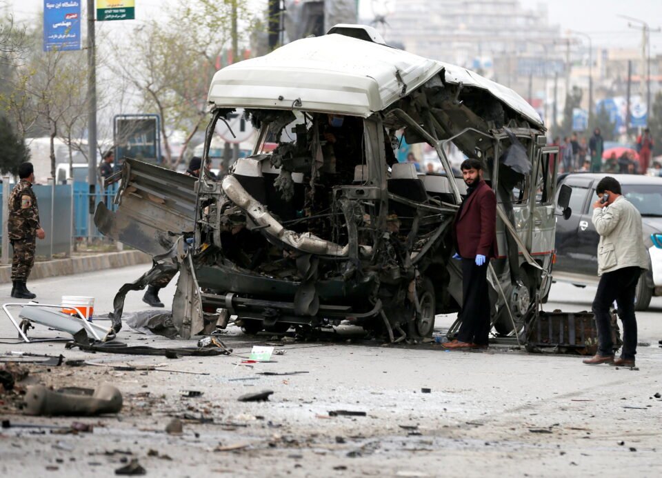 afghan officials inspect a damaged minibus after a blast in kabul