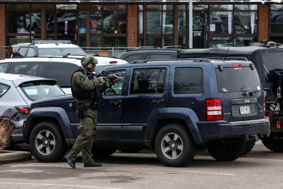 law enforcement officers sweep the parking lot at the site of a shooting at a king soopers grocery store in boulder