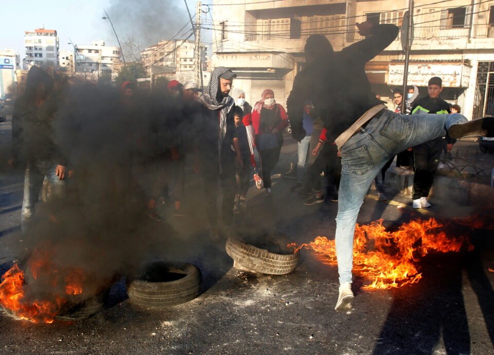demonstrators block a road with burning tires during a protest in sidon