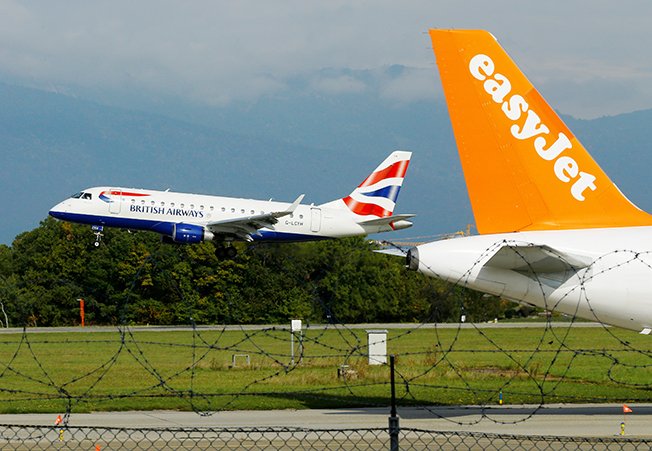 file photo: a british airways aircraft lands next to a easyjet plane ready for take off at cointrin airport in geneva