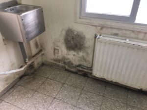 feature gina chipped radiators and mouldy walls in the communal area of the hospital