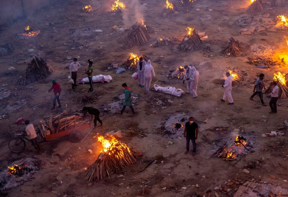 people wait to cremate covid 19 victims at a crematorium ground in new delhi