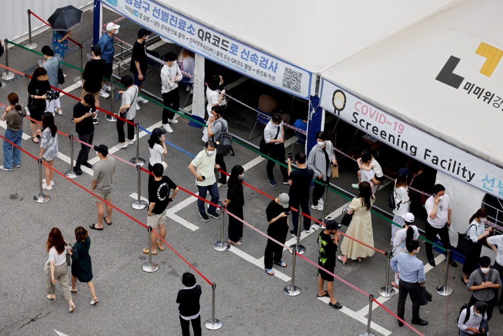 file photo: people wait in line for a coronavirus disease (covid 19) test at a testing site which is temporarily set up at a public health center in seoul