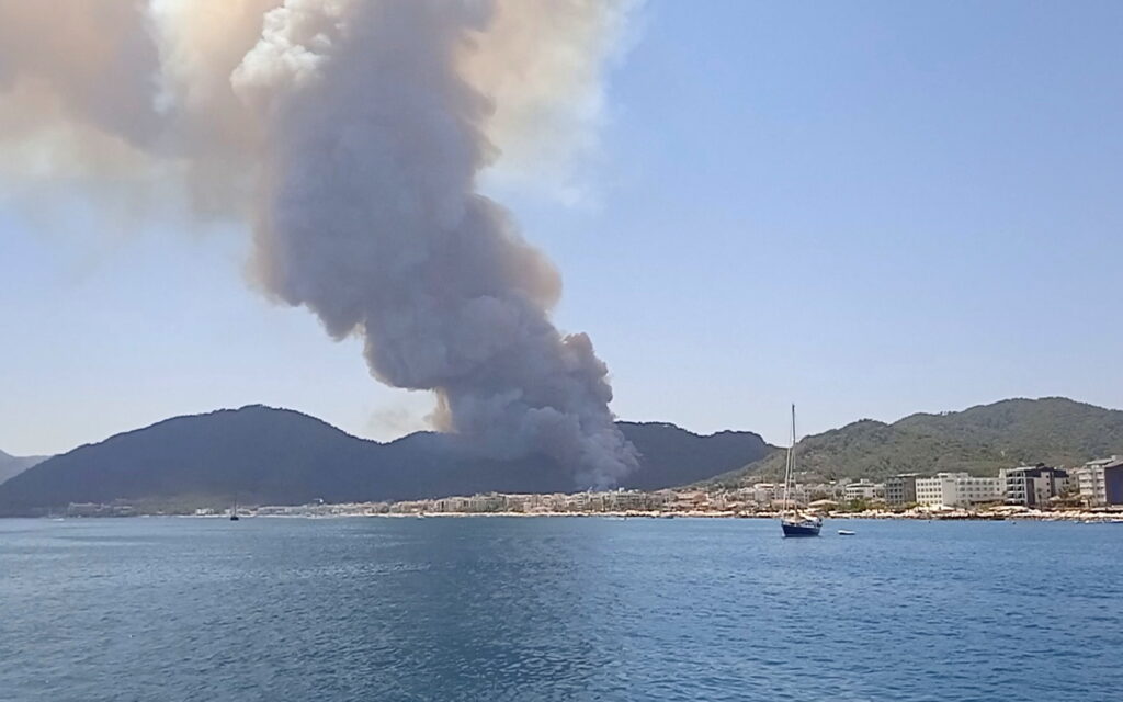 a plume of smoke fills the sky of the coastal resort of marmaris