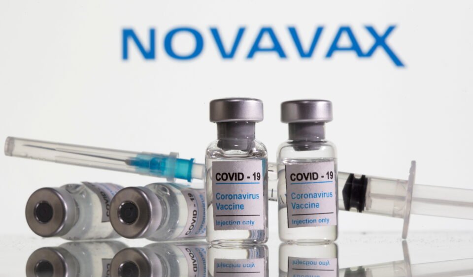file photo: vials labelled "covid 19 coronavirus vaccine" and syringe are seen in front of displayed novavax logo in this illustration
