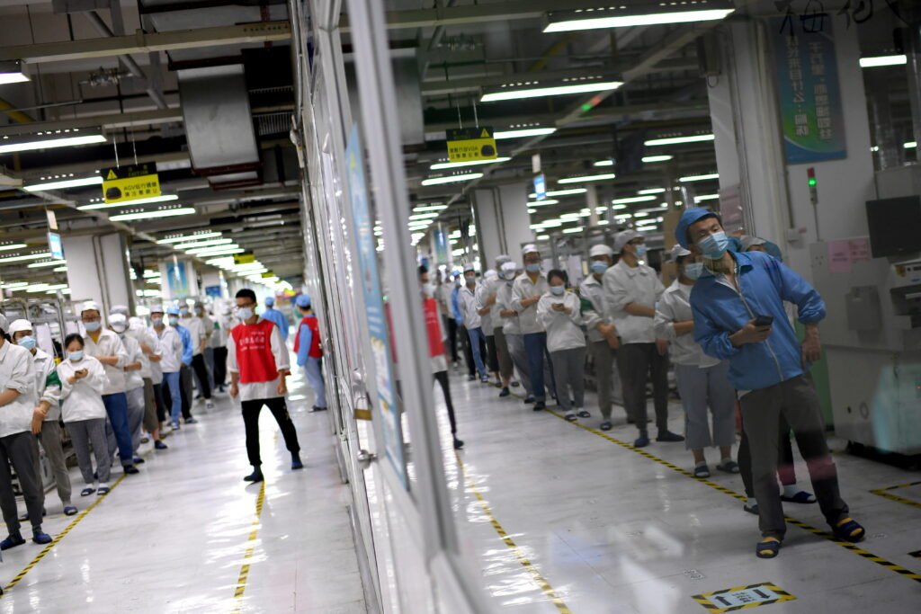 workers line up for nucleic acid testing at a foxconn factory, following new covid 19 cases in wuhan