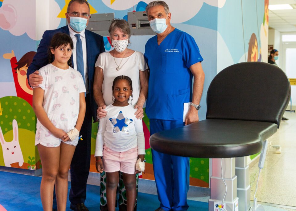 health minister michalis hadjipantelas, cans for kids president rosie charalambous and the medical director of makarios hospital dr pavlos neophytou with two young patients