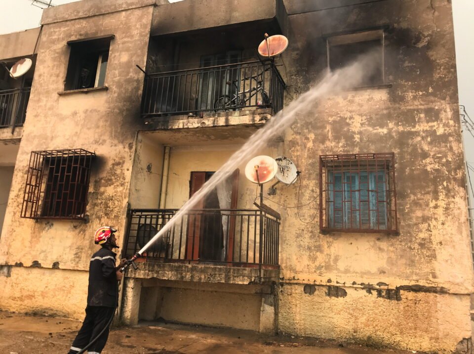 a firefighter uses a water hose after a fire broke out at a building in ain al hammam village