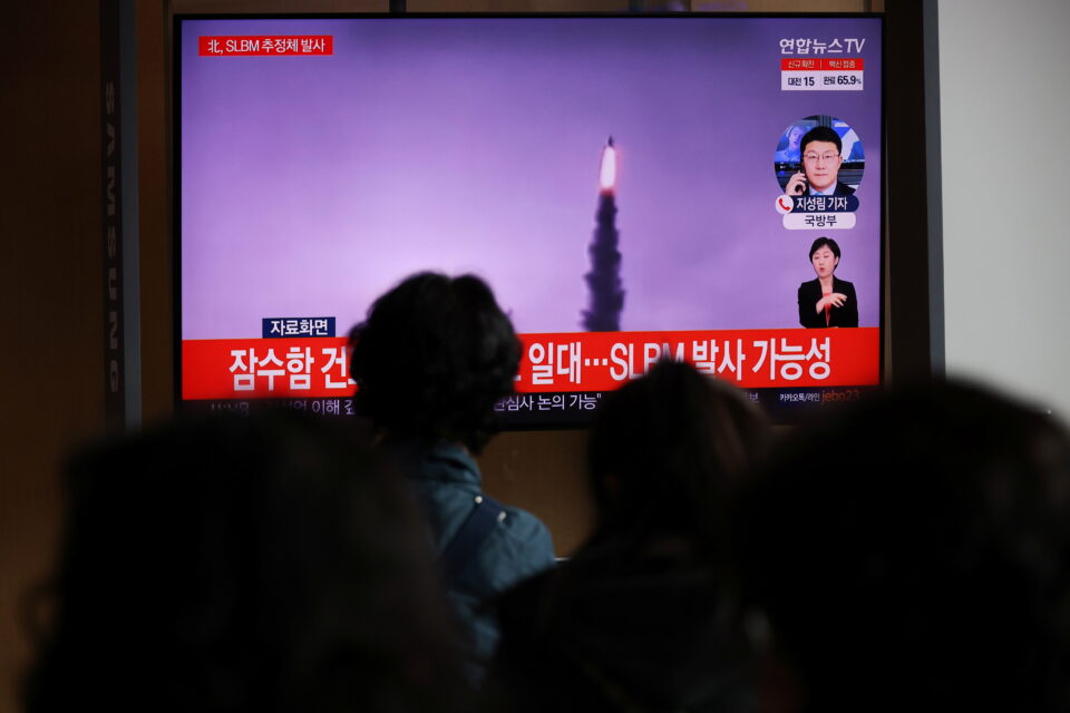 people watch a tv broadcasting file footage of a news report on north korea firing a ballistic missile off its east coast, in seoul