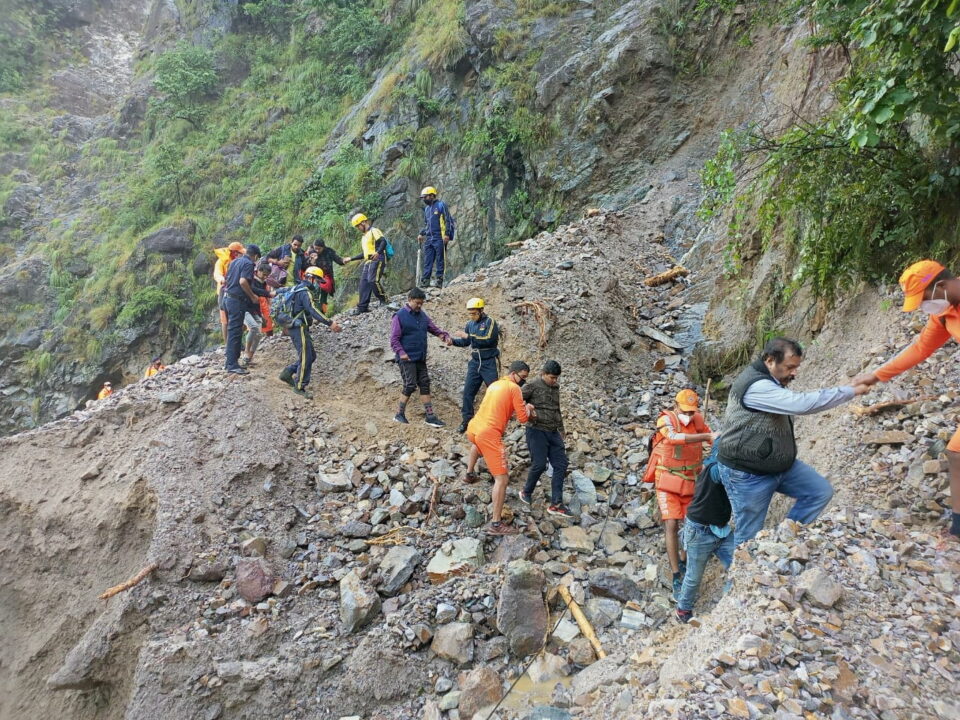 members of national disaster response force evacuate stranded people following heavy rains at chhara village