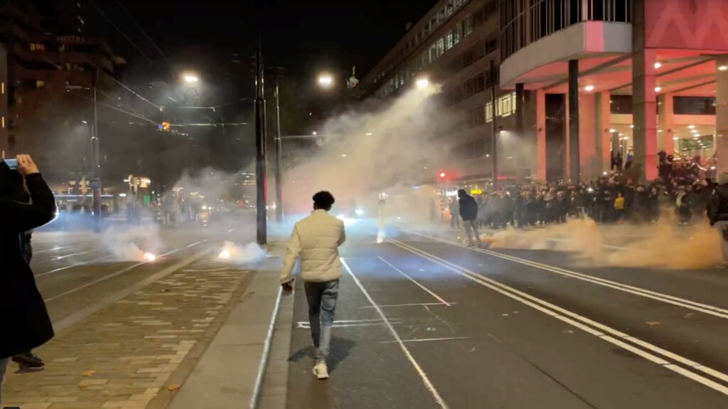 protesters watch smoke flares on as street in rotterdam