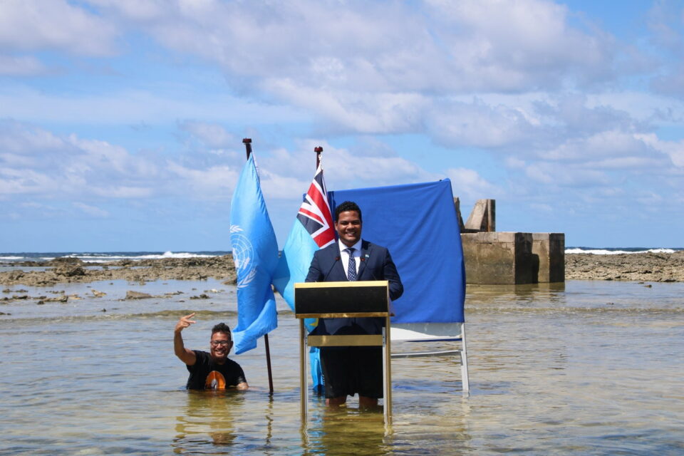 tuvalu's minister for justice, communication & foreign affairs simon kofe gives a cop26 statement while standing in the ocean in funafuti