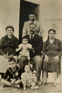 feature paul evagoras as a baby, seated on his father’s lap