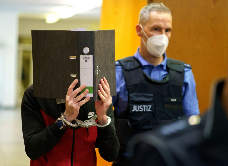 iraqi defendant covers his face as he arrives for his verdict in a courtroom in frankfurt