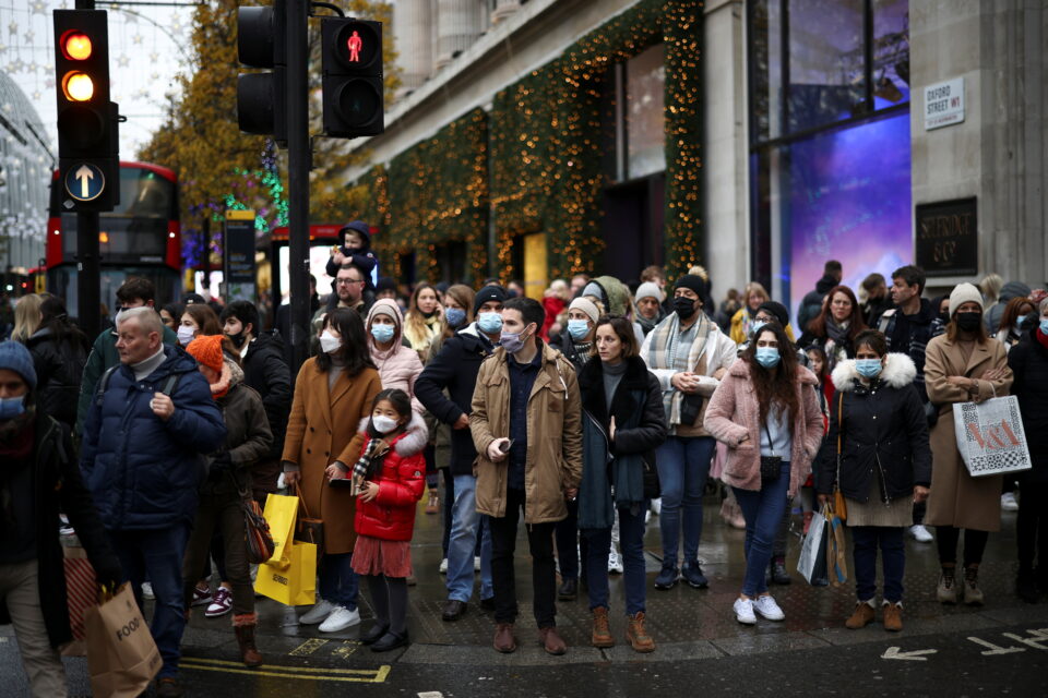 people wait to cross the road along oxford street, amid the covid 19 outbreak in london