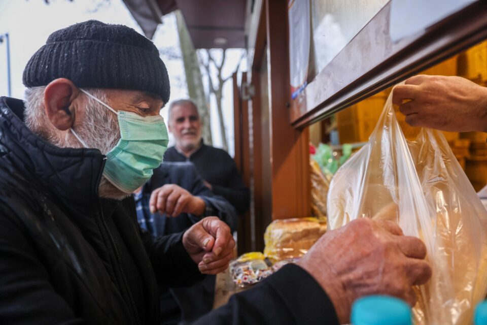 a man buys breads as others queue for istanbul municipality's cheap bread to make small savings in their household budget in sultangazi district of istanbul