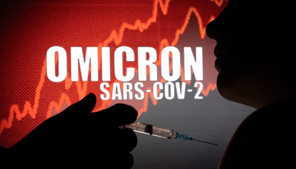 file photo: people pose with syringe with needle in front of displayed words "omicron sars cov 2