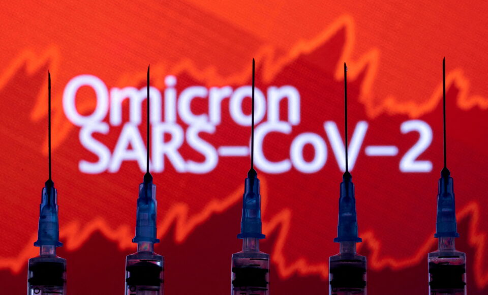 file photo: syringes with needles are seen in front of a displayed stock graph and words "omicron sars cov 2" in this illustration taken