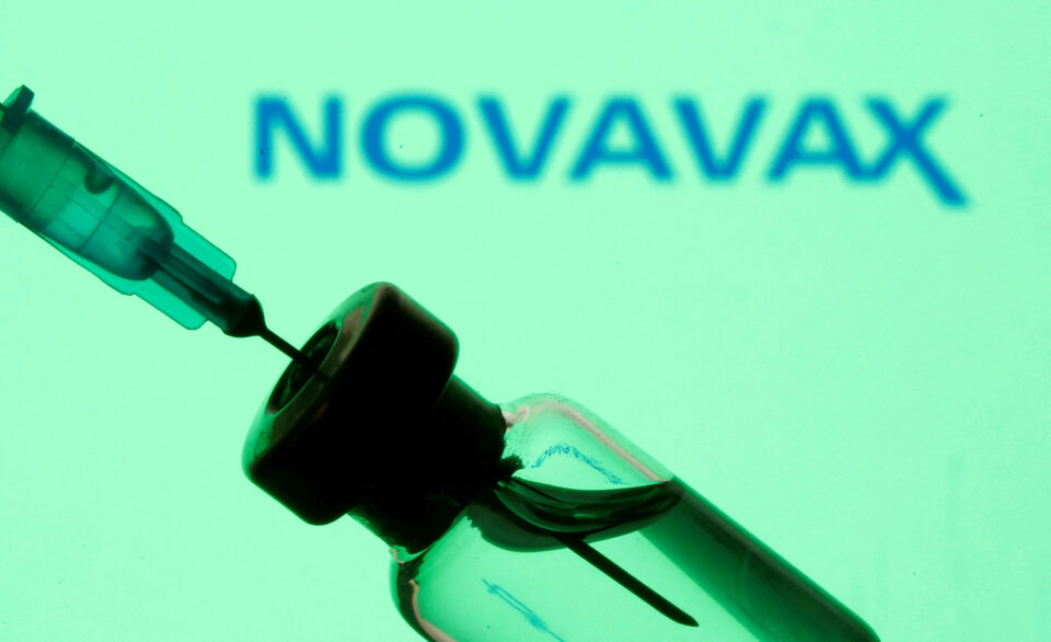 file photo: a vial and sryinge are seen in front of displayed novavax logo in this illustration
