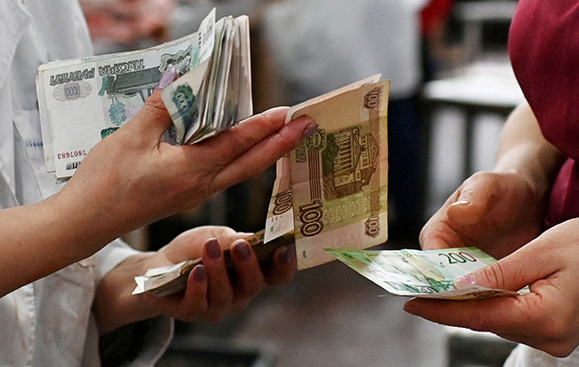 file photo: vendors count russian rouble banknotes at a market in omsk