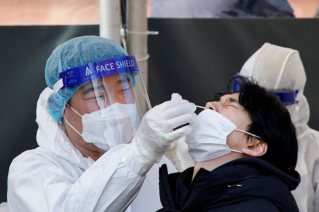 a healthcare worker collects a swab sample from a man to test for covid 19, in seoul