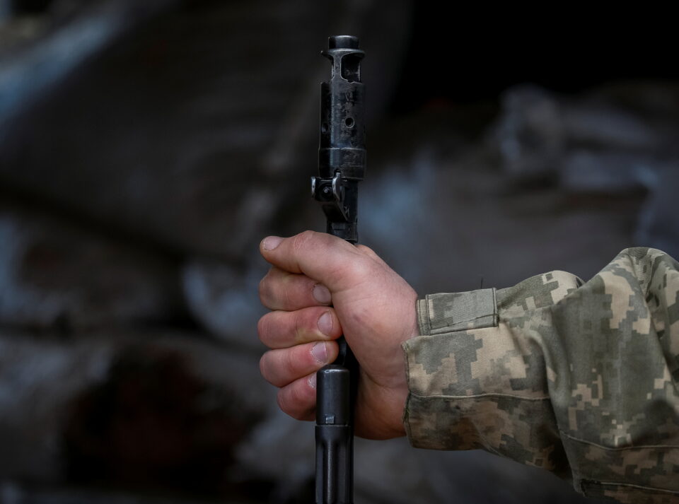ukrainian service member holds a machine gun on the front line near the city of novoluhanske