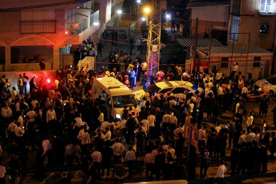 people gather at the scene of an attack in which people were killed by a gunman on a main street in bnei brak, near tel aviv