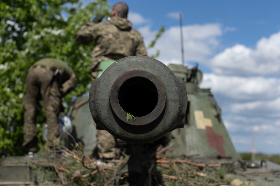 ukrainian soldiers stand on top of a tank in the frontline city of lyman