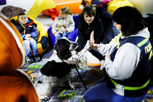 ukrainian children take part in a therapy session with a therapeutic dog, in a complex set up as a shelter organised by volunteers, amid russia's invasion of ukraine, in zaporizhzhya