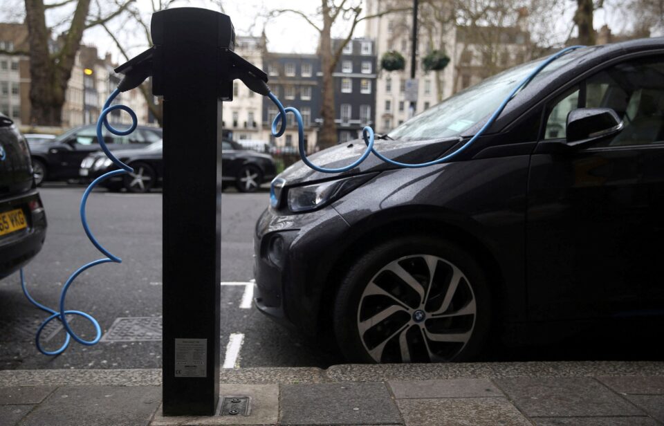 file photo: electric cars are plugged into a charging point in london