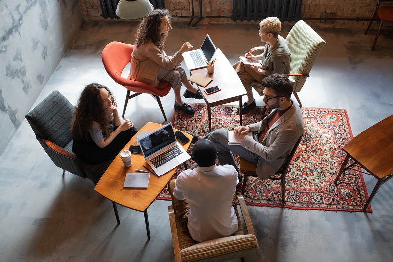 several intercultural business people interacting by tables