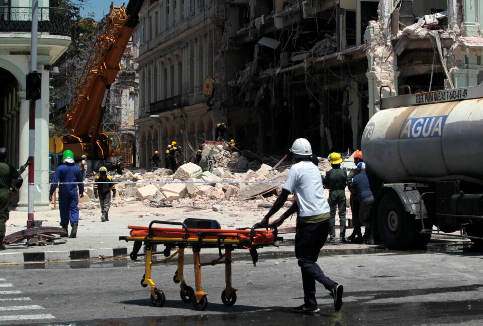 A member of the medical personnel pushes a stretcher as rescue workers remove debris after an explosion hit the Hotel Saratoga, in Havana, Cuba May 6, 2022. REUTERS/Stringer  