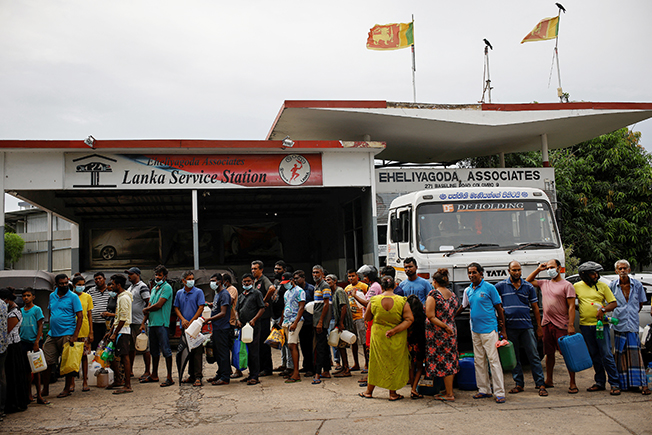 people wait in a queue to buy petrol at a fuel station, amid the country's economic crisis in colombo