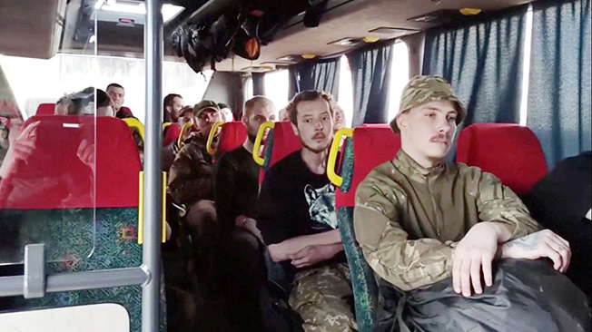 service members of ukrainian forces who left the besieged azovstal steel plant are seen inside a bus in mariupol