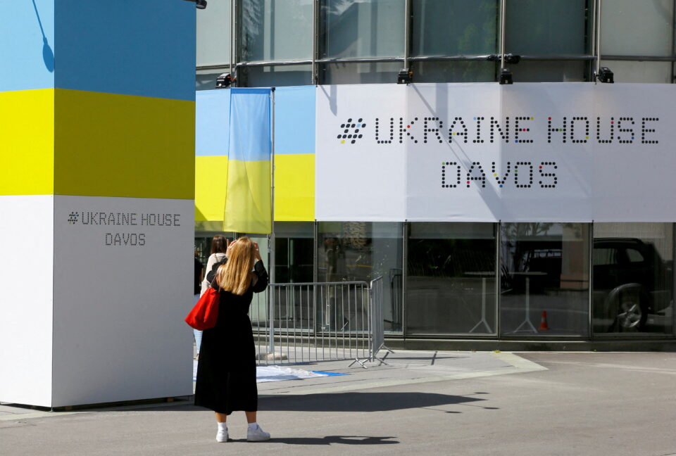 a woman stands in front of the ukraine house davos in davos