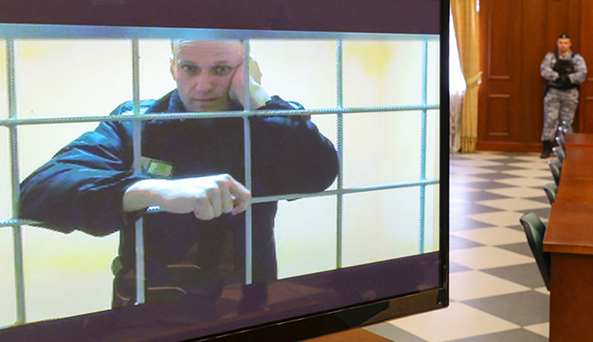 jailed russian opposition leader alexei navalny is seen on a screen during a court hearing in moscow