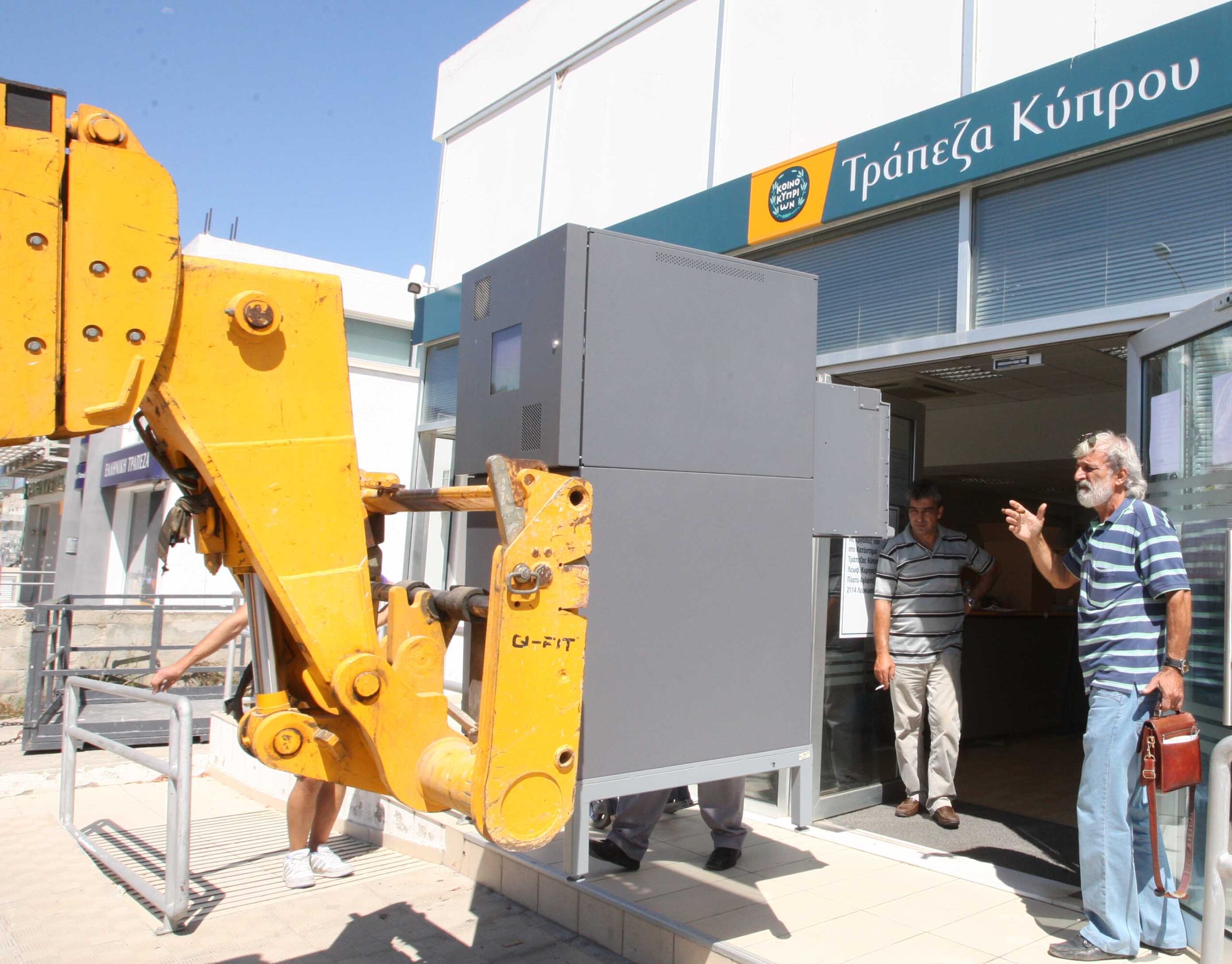 feature nick an atm being removed from a bank of cyprus branch