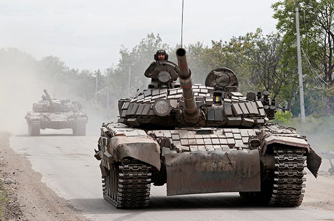tanks of pro russian troops drive along a street in popasna