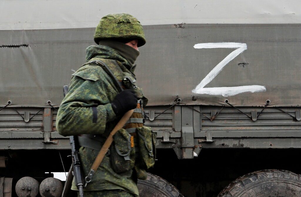 file photo: a serviceman of pro russian militia walks next to a military convoy in the luhansk region
