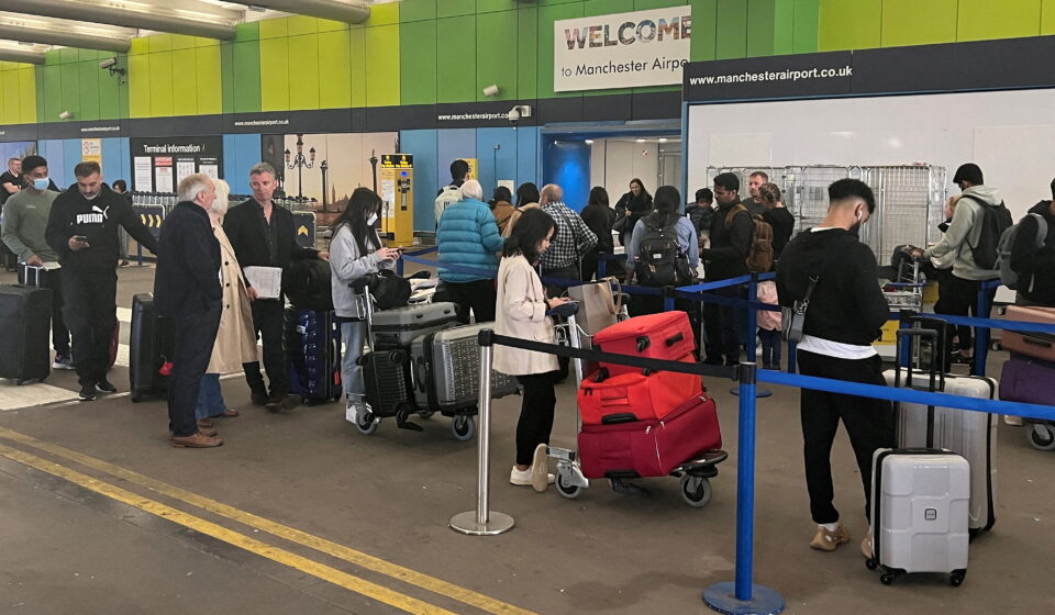 file photo: passengers queue for check in outside terminal 1 at manchester airport