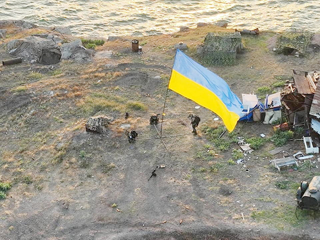 ukrainian service members install national flag on snake (zmiinyi) island